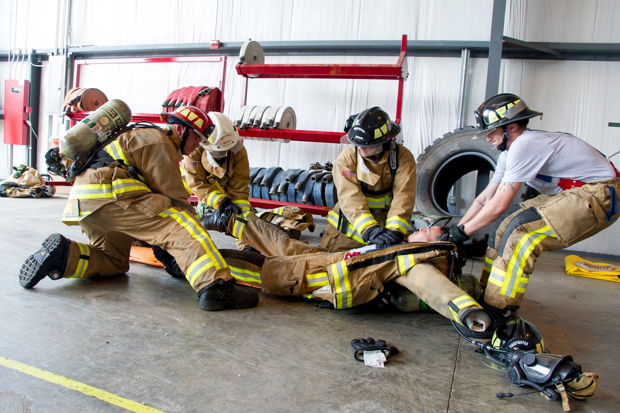 Firefighters remove firefighting gear and simulate CPR on U.S. Air Force Staff Sgt. Joshua Hayworth, of Waianae, Hawaii, as he acts out a cardiac arrest incident during a training scenario for the first-ever Air Force Reserve Command Firefighter Rescue and Survival Course at Dobbins Air Reserve Base, Ga., April 18, 2017. Twenty Citizen Airmen participated in the intense 50-hour course held at the 622nd Civil Engineer Group expeditionary combat support-training certification center, which focused on a Rapid Intervention Crew, or RIC. The RIC is a dedicated and specially trained group of firefighters whose responsibilities include safely evacuating a distressed firefighter from a structure. (U.S. Air Force photo by Master Sgt. Theanne K. Herrmann)