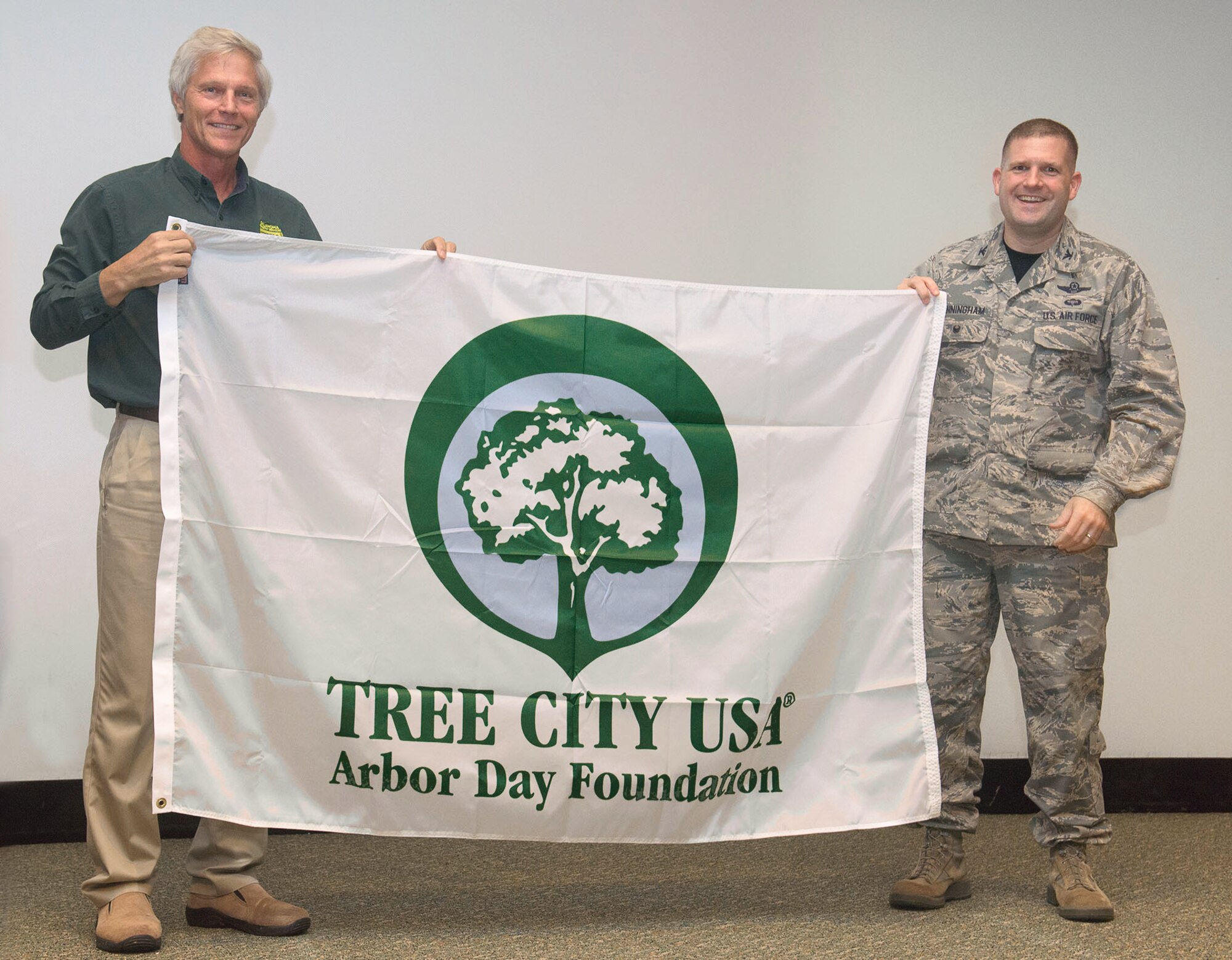 A Tree City flag was presented to Col. Fred Cunningham, right, the 71st Flying Training Wing vice commander, by Mark Bays, Urban Forester with the Oklahoma Forestry Services, during a ceremony naming Vance Air Force Base a Tree City USA for the 24th year, held April 21 in the base auditorium. (U.S. Air Force photo/ Terry Wasson)