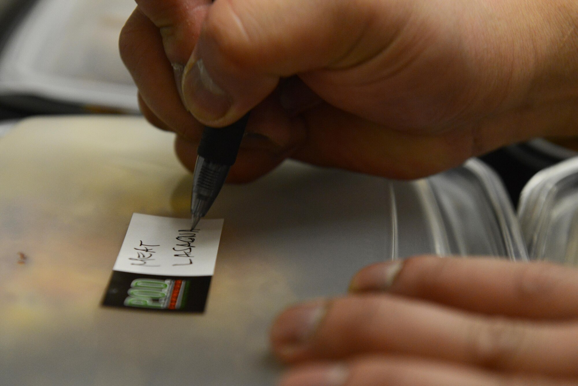 Rodel Magno, 673d Force Support Squadron Iditarod Dining Facility cook, writes the contents of the meal on to-go containers for the Provisions on Demand at Joint Base Elmendorf-Richardson, Alaska, April 25, 2017. The meals are in to-go containers because the POD’s primary customers are flightline personnel who do not have a lot of time and need hot meals. 