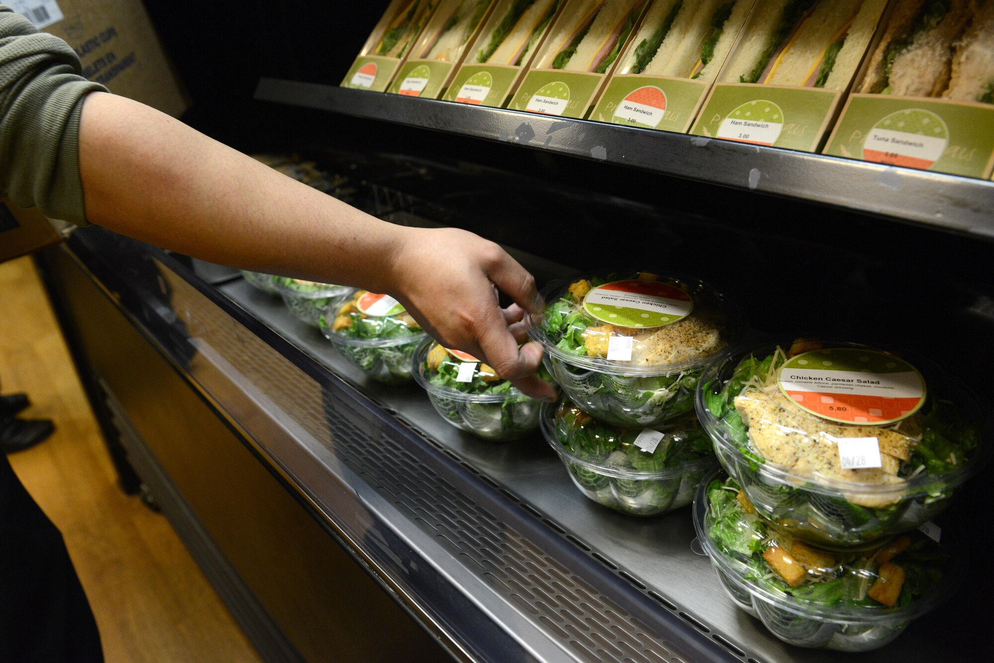 Rodel Magno, 673d Force Support Squadron Iditarod Dining Facility cook, places salads at the Provisions on Demand at Joint Base Elmendorf-Richardson, Alaska, April 25, 2017. The meals are in to-go containers because the POD’s primary customers are flightline personnel who do not have a lot of time and need hot meals. 