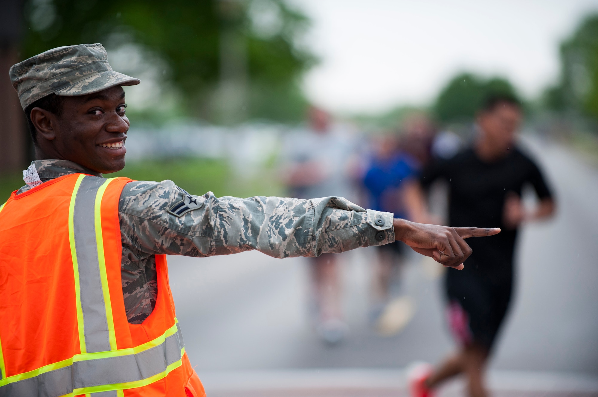 A volunteer guides runners during the Race Through Scott's Past, at Scott Air Force Base, Illinois, April 21. Volunteers were stationed throughout the course to keep runners on the correct course. (U.S. Air Force photo by Staff Sgt. Clayton Lenhardt)