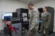 Maj. Maggie Coppini, 412th Medical Group aerospace physiologist, watches Col. Scott Cain, 412th Operations Group commander, cut the ceremonial ribbon signifying the introduction of a new hypoxia trainer located at the 412th Operations Support Squadron’s Aircrew Flight Equipment Aircrew Operations building April 20. (U.S. Air Force photo by Kyle Larson)