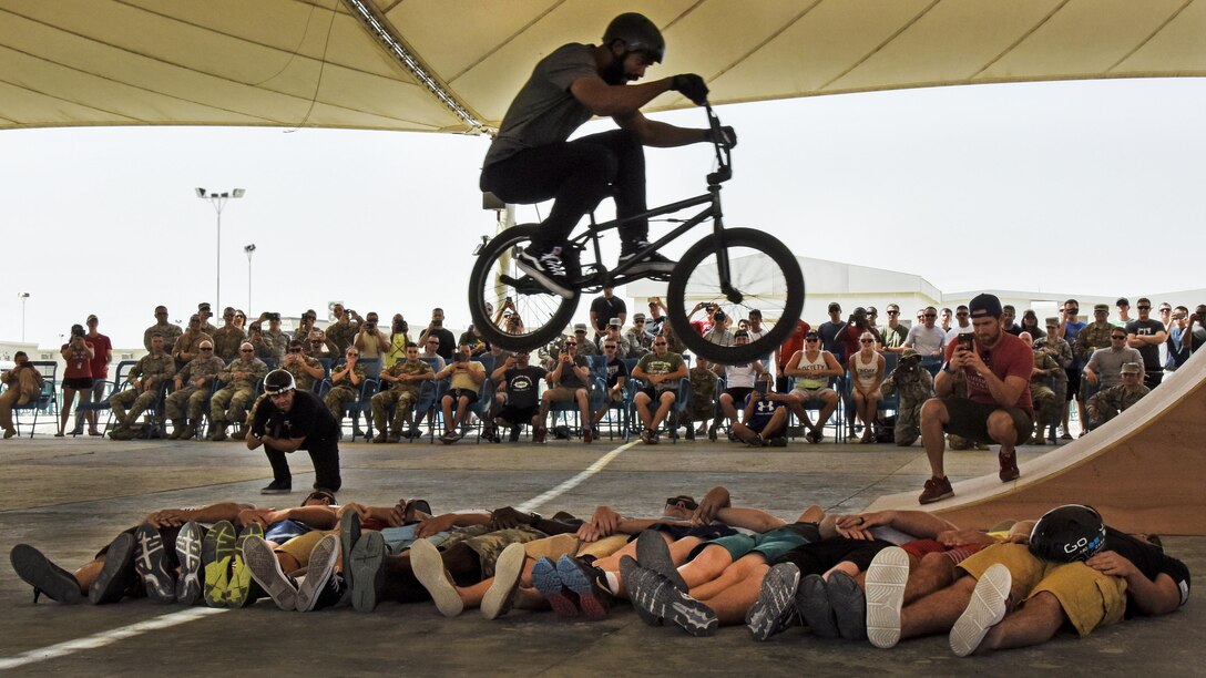 Mykel Larrin, a Bikes Over Baghdad BMX rider, jumps over service members at Al Udeid Air Base in Qatar, April 20, 2017. Bikes Over Baghdad is a professional team of BMX riders who travel throughout the U.S. Central Command area of responsibility putting on shows for service members. Air Force photo by Senior Airman Cynthia A Innocenti