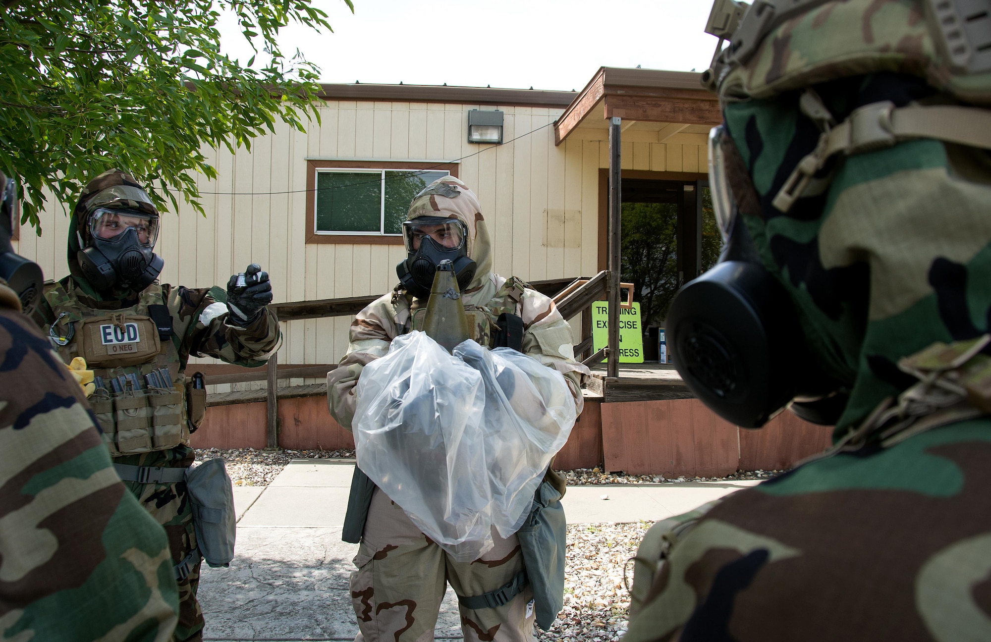 Airmen 1st Class Justin Coleman and Ryan Countryman, 60th Civil Engineer Squadron explosive ordnance technicians, participate in a contamination control of an ordnance training scenario at Travis Air Force Base, Calif., on April 17, 2017. EOD techs conduct training on various threats to ensure they are prepared for deployment. (U.S.Air Force photo/Staff Sgt. Daniel Phelps)