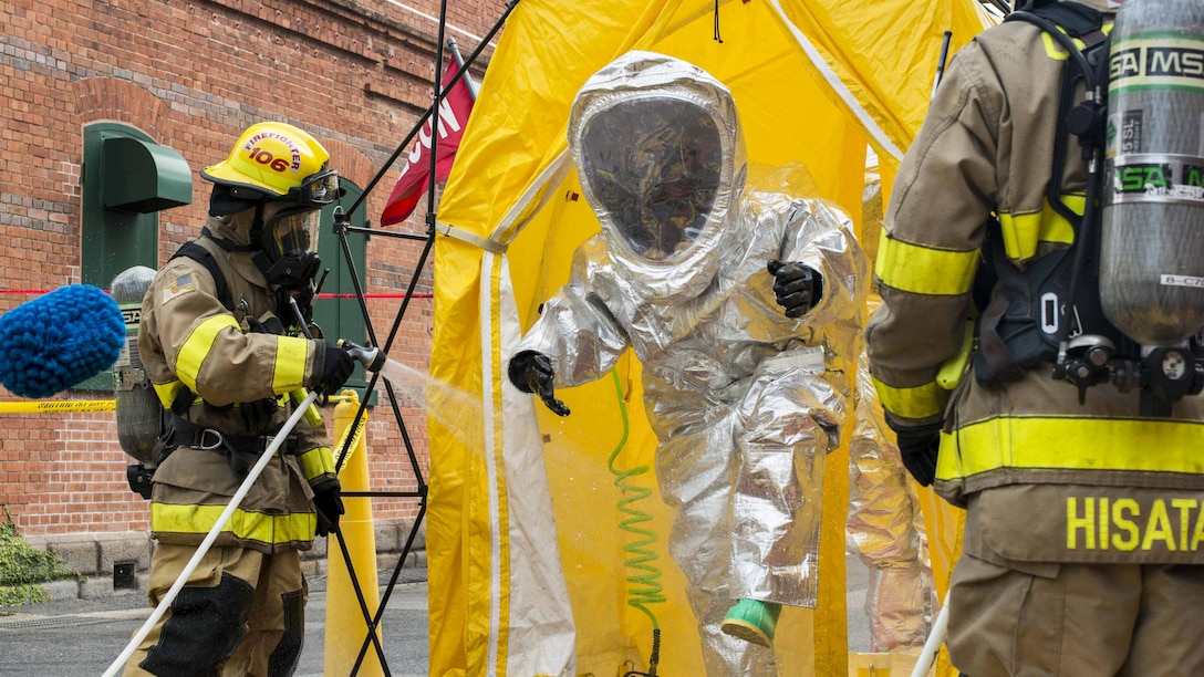 Sailors decontaminate a fire proximity suit during Exercise Reliant Gale at Commander, U.S. Fleet Activities Sasebo, Japan, April 18, 2017. The exercise trains naval installations in emergency preparedness and personnel accountability, evacuation and recovery operations from a catastrophic natural disaster. The sailors are assigned to Commander Naval Forces Japan Fire and Emergency Services. Navy photo by Seaman Geoffrey P. Barham