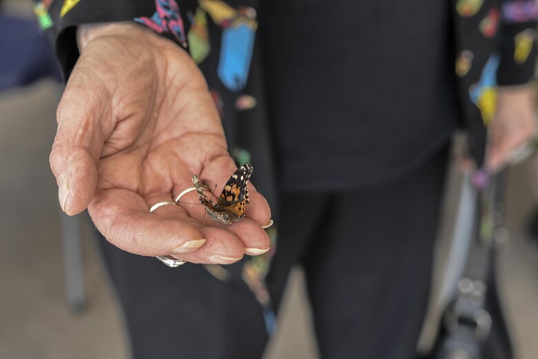 Annique Dveirin, Holocaust survivor, releases a butterfly during a Holocaust remembrance ceremony at Davis-Monthan Air Force Base, Ariz., April 24, 2017. The butterflies were released to signify hope, transformation and freedom. (U.S. Air Force photo by Airman 1st Class Giovanni Sims)