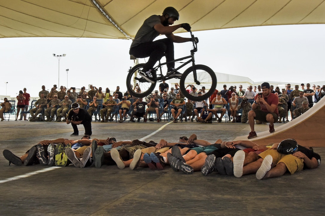 Mykel Larrin, a Bikes Over Baghdad BMX rider, jumps over service members at Al Udeid Air Base in Qatar, April 20, 2017. Bikes Over Baghdad is a professional team of BMX riders who travel throughout the U.S. Central Command area of responsibility putting on shows for service members. Air Force photo by Senior Airman Cynthia A Innocenti