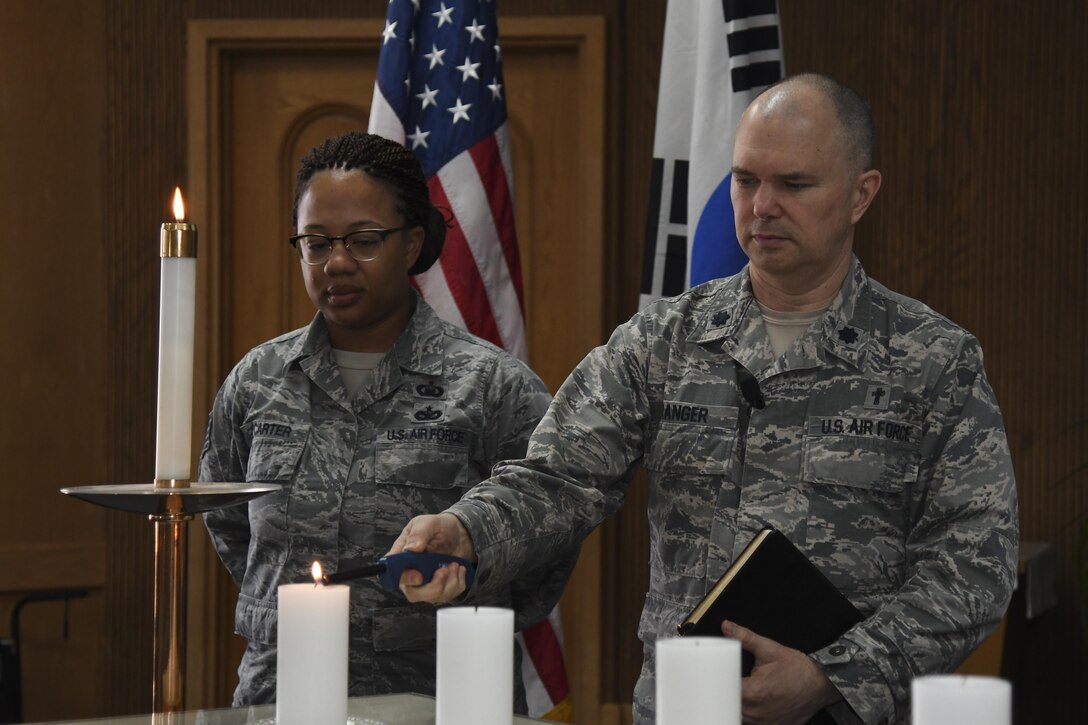 U.S. Air Force Chap. (Lt. Col.) Jeffery Granger, 51st Fighter Wing chaplain, lights a candle during a Holocaust Remembrance Day ceremony at Osan Air Base, Republic of Korea, April 25, 2017. Six candles were lit at the end of the ceremony to represent the estimated 6 million Jews executed during the Holocaust. (U.S. Air Force photo by Airman 1st Class Gwendalyn Smith)