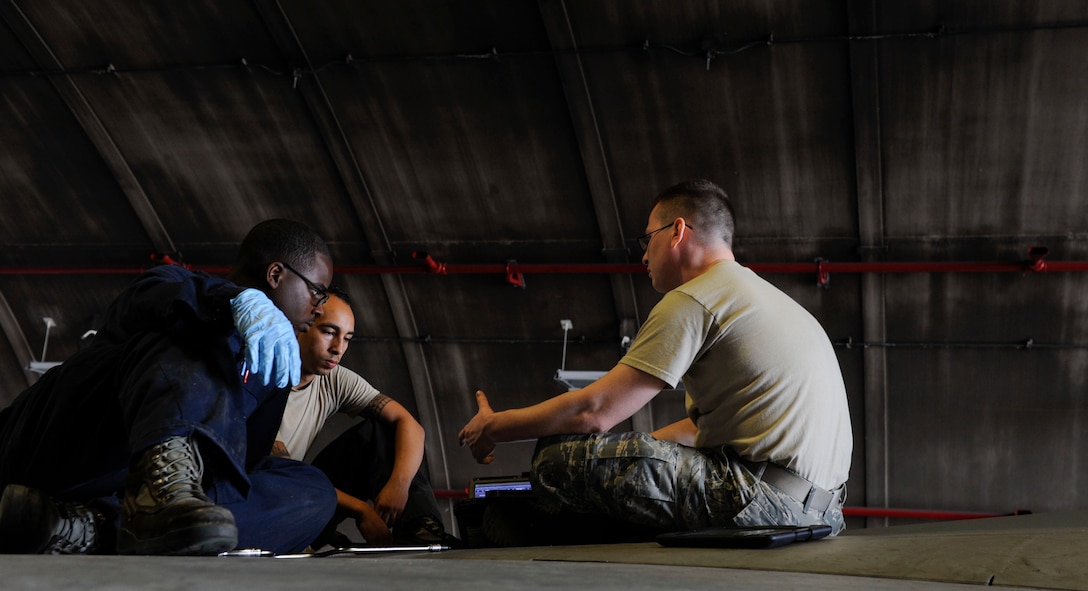 U.S. Air Force Airman 1st Class Tychaun Kingston, 44th Aircraft Maintenance Unit crew chief, Senior Airman Devon Moore, 67th AMU crew chief and Tech. Sgt. Timothy Peppler, 372nd Training Squadron, Detachment 15, F-15 Eagle aircraft maintenance instructor, discuss maintenance training April 24, 2017, at Kadena Air Base, Japan. Before performing a training task, crew chiefs and training instructors review what needs to be done and how it will be carried out. (U.S. Air Force photo by Senior Airman Lynette M. Rolen)
