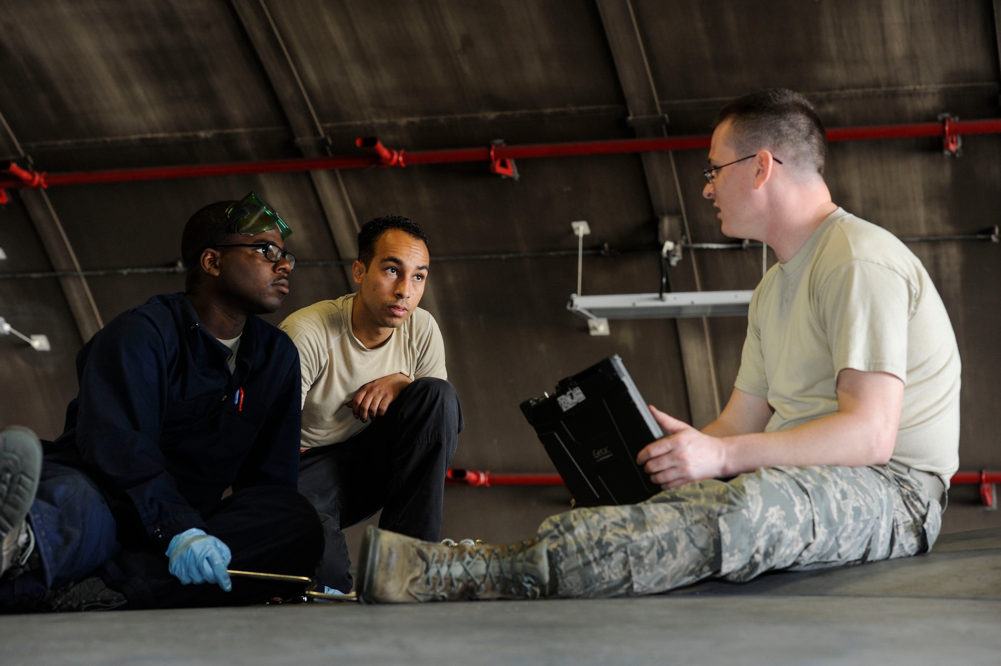 U.S. Air Force Tech. Sgt. Timothy Peppler, 372nd Training Squadron, Detachment 15, F-15 Eagle aircraft maintenance instructor, Senior Airman Devon Moore, 67th Aircraft Maintenance Unit crew chief, and Airman 1st Class Tychaun Kingston, 44th AMU crew chief, review training content April 24, 2017, at Kadena Air Base, Japan. After Airmen complete each training task, the instructor reviews their actions and provides feedback. (U.S. Air Force photo by Senior Airman Lynette M. Rolen)