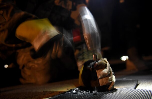 Airman 1st Class Brandon Ramirez, 455th Expeditionary Civil Engineer Squadron, punches a hole into a segment of tape April 20, 2017, at Bagram Airfield, Afghanistan. The tape is one component of the Mobile Aircraft Arresting System, which is used to rapidly decelerate a landing plane, primarily fighters. The system is crucial for landings where the runway is too short or there is brake failure. (U.S. Air Force photo by Staff Sgt. Benjamin Gonsier)