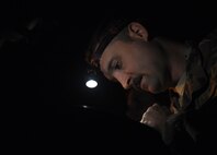 Staff Sgt. Jared Latham, 455th Expeditionary Civil Engineer Squadron, inspects a new tape as it is inserted in a reel April 20, 2017, at Bagram Airfield, Afghanistan. Civil engineers conducted routine maintenance on a Mobile Aircraft Arresting System, which is used to rapidly decelerate an aircraft. (U.S. Air Force photo by Staff Sgt. Benjamin Gonsier)