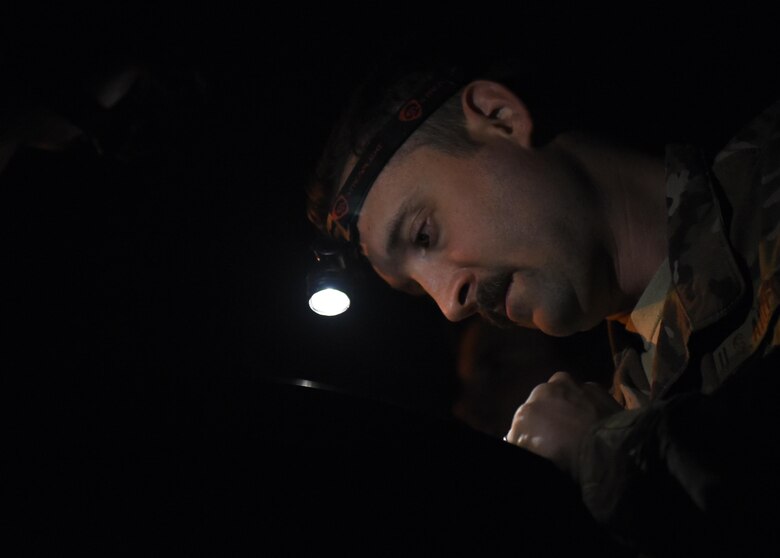 Staff Sgt. Jared Latham, 455th Expeditionary Civil Engineer Squadron, inspects a new tape as it is inserted in a reel April 20, 2017, at Bagram Airfield, Afghanistan. Civil engineers conducted routine maintenance on a Mobile Aircraft Arresting System, which is used to rapidly decelerate an aircraft. (U.S. Air Force photo by Staff Sgt. Benjamin Gonsier)