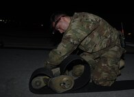 Airman Anson Stuart, 455th Expeditionary Civil Engineer Squadron, reeves tape into a tape connector April 20, 2017, at Bagram Airfield, Afghanistan. The tape connector is fastened to the hook cable, which is the part of the Mobile Aircraft Arresting System that catches a landing aircraft. (U.S. Air Force photo by Staff Sgt. Benjamin Gonsier)