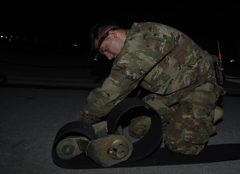 Airman Anson Stuart, 455th Expeditionary Civil Engineer Squadron, reeves tape into a tape connector April 20, 2017, at Bagram Airfield, Afghanistan. The tape connector is fastened to the hook cable, which is the part of the Mobile Aircraft Arresting System that catches a landing aircraft. (U.S. Air Force photo by Staff Sgt. Benjamin Gonsier)