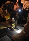 Airman 1st Class Brandon Ramirez, 455th Expeditionary Civil Engineer Squadron power production apprentice, punches a hole into a tape connector April 20, 2017, at Bagram Airfield, Afghanistan. The tape connector is one component of the Mobile Aircraft Arresting System, which is used to rapidly decelerate a landing plane, primarily fighters. The system is crucial for landings where the runway is too short or there is brake failure. (U.S. Air Force photo by Staff Sgt. Benjamin Gonsier)