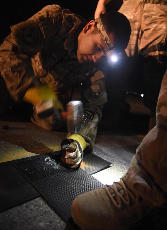 Airman 1st Class Brandon Ramirez, 455th Expeditionary Civil Engineer Squadron power production apprentice, punches a hole into a tape connector April 20, 2017, at Bagram Airfield, Afghanistan. The tape connector is one component of the Mobile Aircraft Arresting System, which is used to rapidly decelerate a landing plane, primarily fighters. The system is crucial for landings where the runway is too short or there is brake failure. (U.S. Air Force photo by Staff Sgt. Benjamin Gonsier)