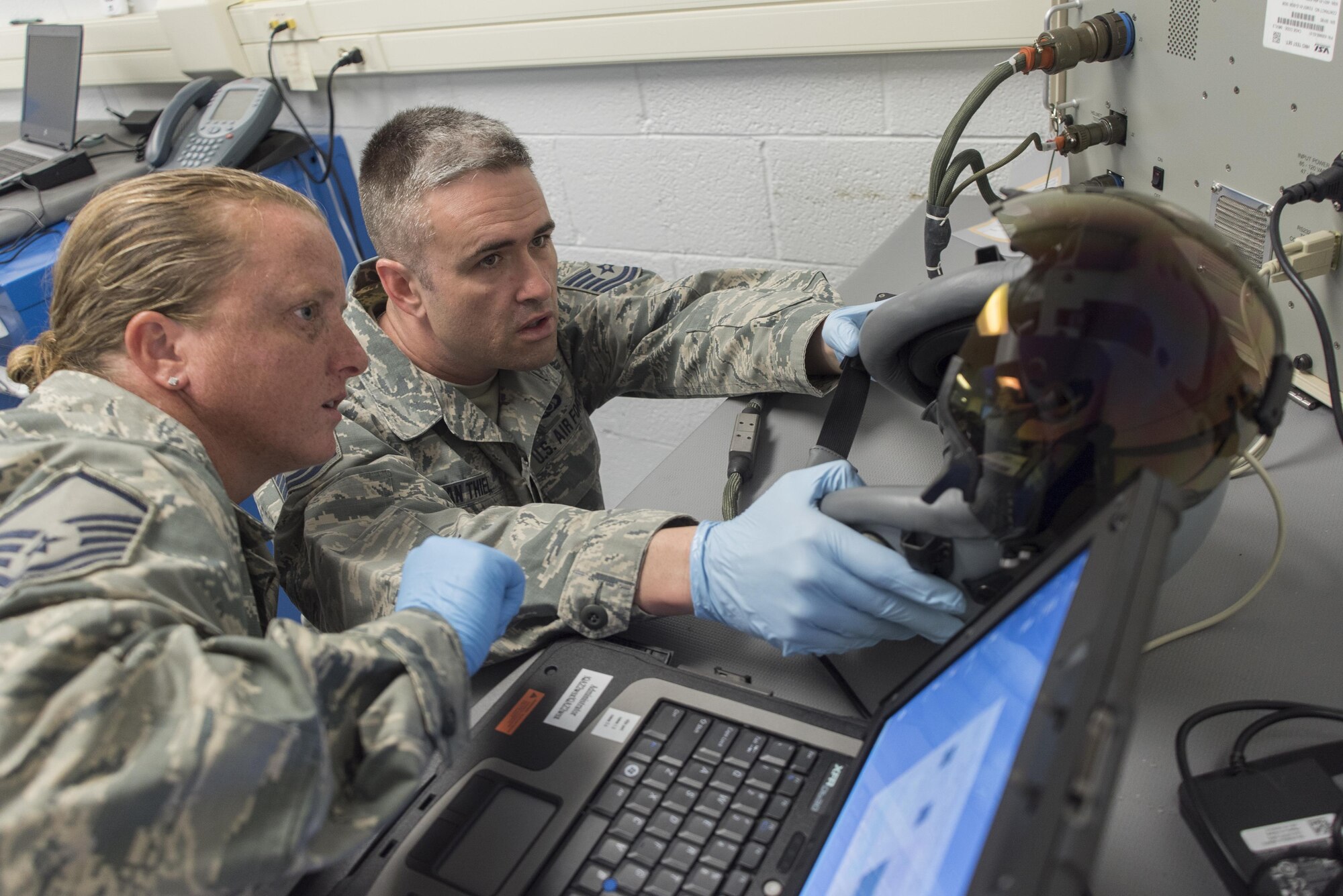 Master Sgt. Brandi Bray and Tech. Sgt. Eduard Van Thiel, 339th Flight Test Squadron aircrew flight equipment, operate a head-mounted display test system April 26, 2017, at Robins Air Force Base, Georgia. Aircrew flight equipment Airmen with the 339th FLTS are responsible for performing inspections, maintenance and adjustments to F-15 and C-5 flight and safety equipment. (U.S. Air Force photo by Jamal D. Sutter)  