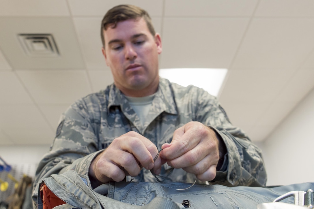 Staff Sgt. Scott Watson, 339th Flight Test Squadron aircrew flight equipment technician, secures a beacon to a parachute harness April 26, 2017, at Robins Air Force Base, Georgia. Watson has been with the unit for a year. (U.S. Air Force photo by Jamal D. Sutter)