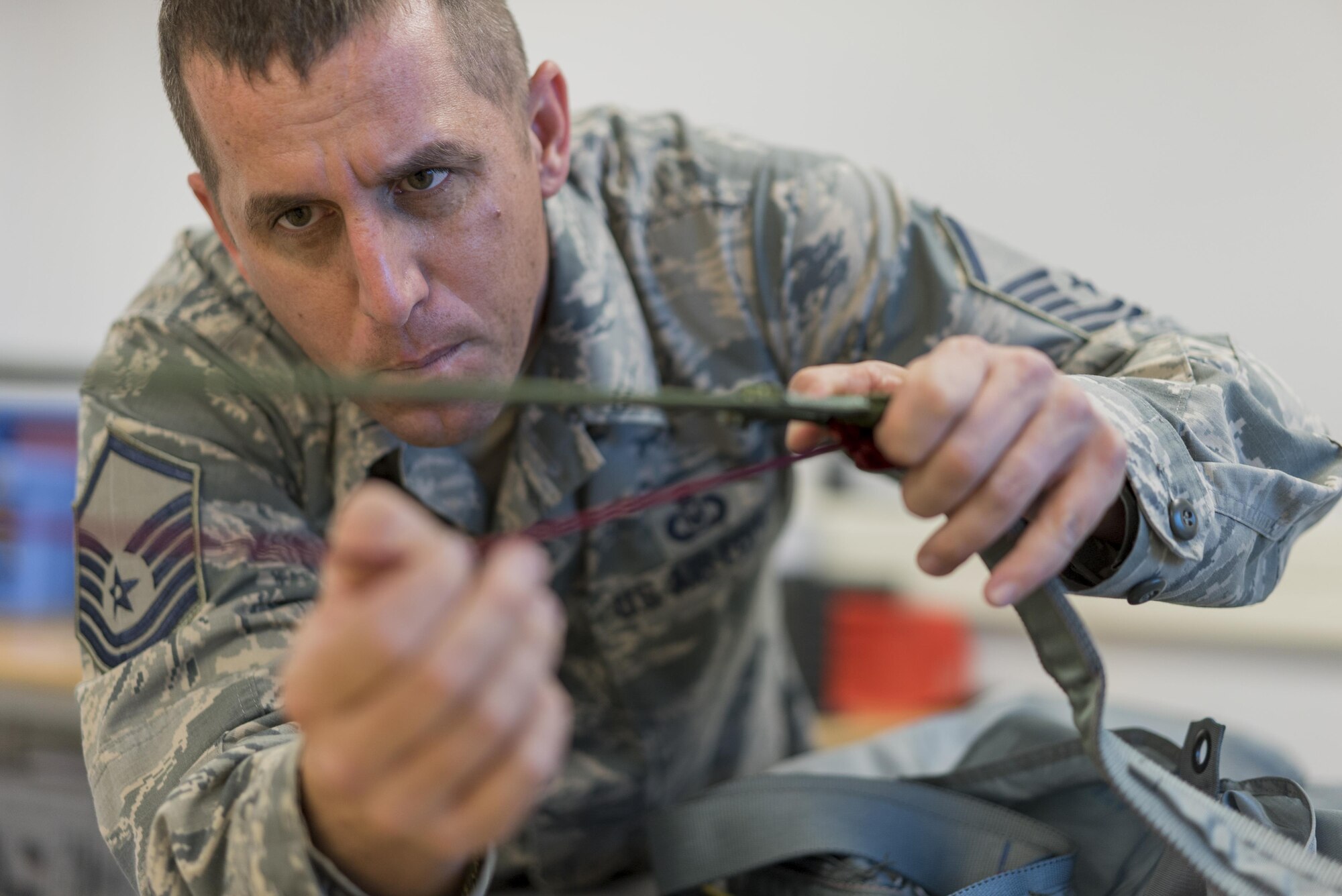 Master Sgt. Kevin Spano, 339th Flight Test Squadron aircrew flight equipment NCO in charge, inspects parachute lines April 26, 2017, at Robins Air Force Base, Georgia. One thing to look for when inspecting parachute lines is to ensure no lines are tangled together. (U.S. Air Force photo by Jamal D. Sutter)