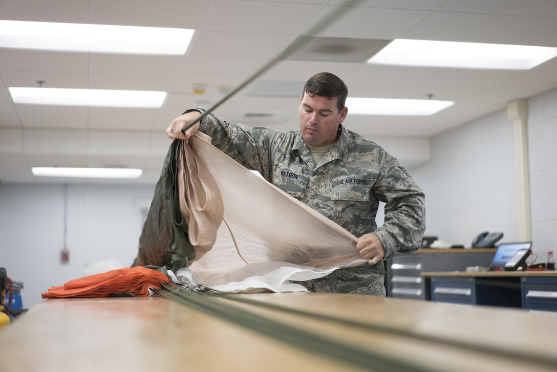 Staff Sgt. Scott Watson, 339th Flight Test Squadron aircrew flight equipment technician, inspects a parachute April 26, 2017, at Robins Air Force Base, Georgia. Aircrew flight equipment Airmen with the 339th FLTS are responsible for performing inspections, maintenance and adjustments to F-15 and C-5 flight and safety equipment. (U.S. Air Force photo by Jamal D. Sutter)