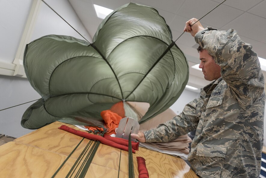 Staff Sgt. Scott Watson, 339th Flight Test Squadron aircrew flight equipment technician, inspects a parachute April 26, 2017, at Robins Air Force Base, Georgia. Aircrew flight equipment specialists ensure all flight and safety equipment are operational and able to be fully utilized during operations and emergency situations. (U.S. Air Force photo by Jamal D. Sutter)