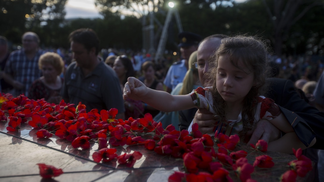 Citizens of Australia place Red Poppy flowers on an ANZAC memorial, in Darwin, Australia, April 25, 2017. Australia and New Zealand celebrate ANZAC Day as a way to thank all who has served and to honor all who gave the greatest sacrifice.