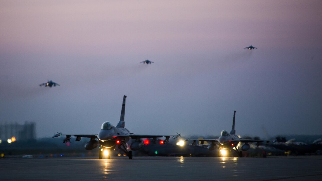 U.S. Air Force F-16 Fighting Falcons taxi down the runway as U.S. Marine Corps AV-8B Harriers take off during Exercise Max Thunder 17 at Kunsan Air Base, Republic of Korea, April 26, 2017. Max Thunder serves as an opportunity for U.S. and ROK forces to train together and sharpen tactical skills for the defense of the Asia-Pacific region. It is an annual military-flying exercise built to promote interoperability between U.S. and ROK forces.