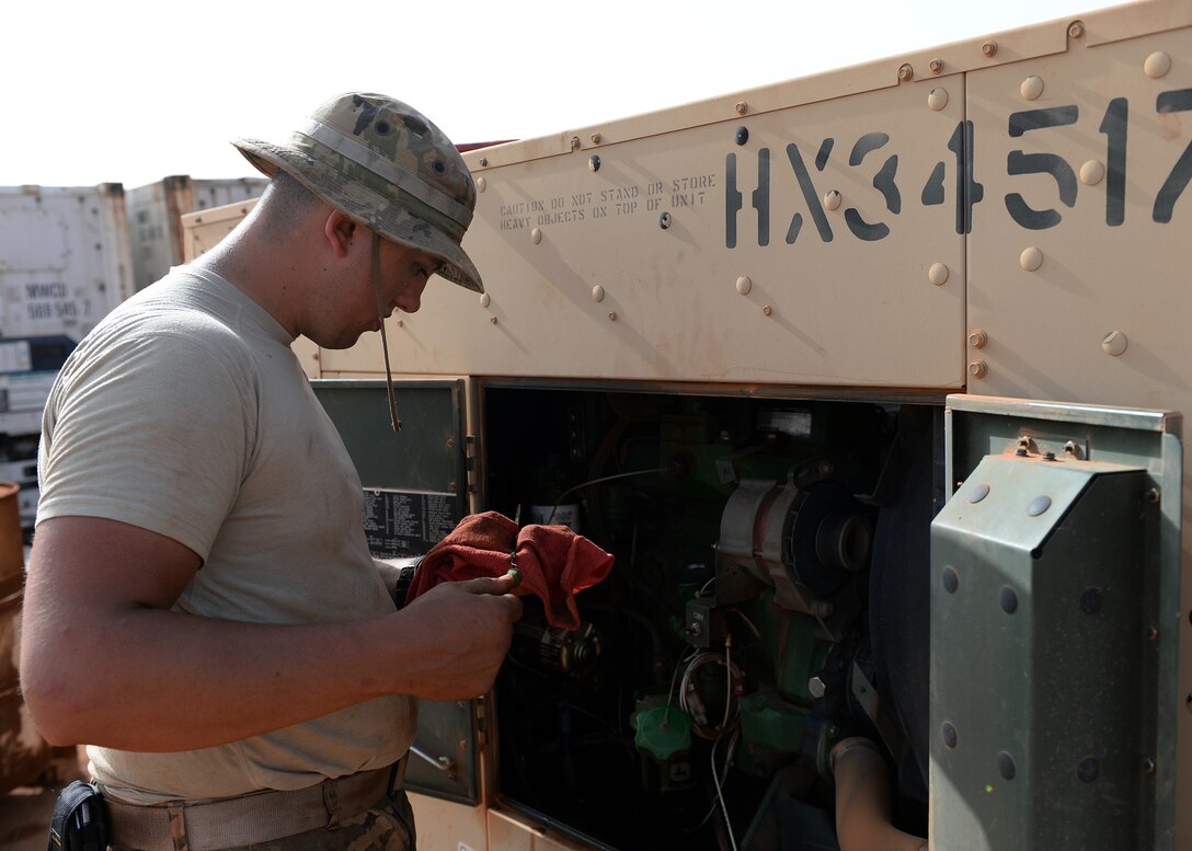 Senior Airman Edward Conrad, 768th Expeditionary Air Base Squadron Power Production journeyman, checks the oil dipstick after changing the oil of a generator at Nigerien Air Base 101, Niger, April 1, 2017. Each generator is rated at 10,000 hours before needing more in depth Inspections and maintenance. (U.S. Air Force photo by Senior Airman Jimmie D. Pike)