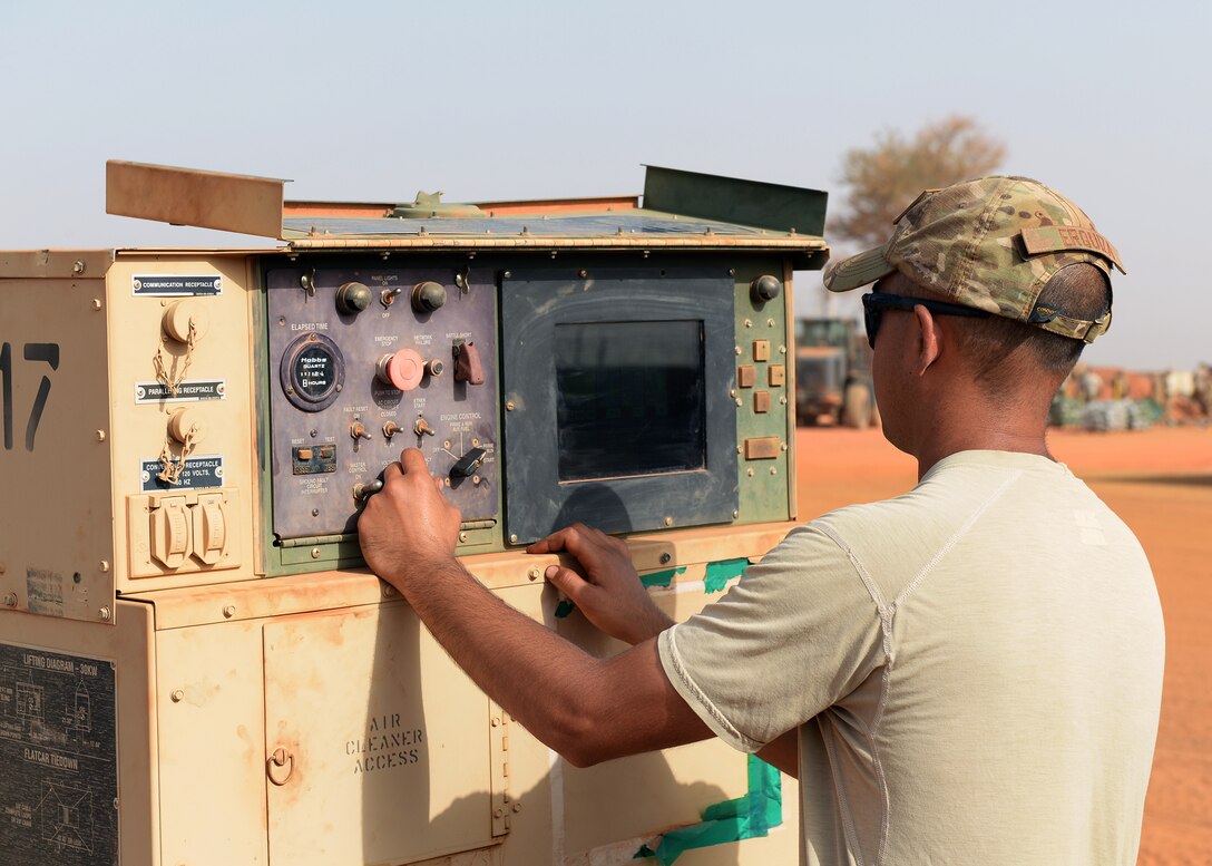 Staff Sgt. Eric Erquiza, 768th Expeditionary Air Base Squadron NCO in charge of Power Production, checks the settings on a generator at Nigerien Air Base 101, Niger, April 1, 2017. Periodic maintenance on the generators helps to cut down on wear and tear, and keeps them operating efficiently. (U.S. Air Force photo by Senior Airman Jimmie D. Pike)