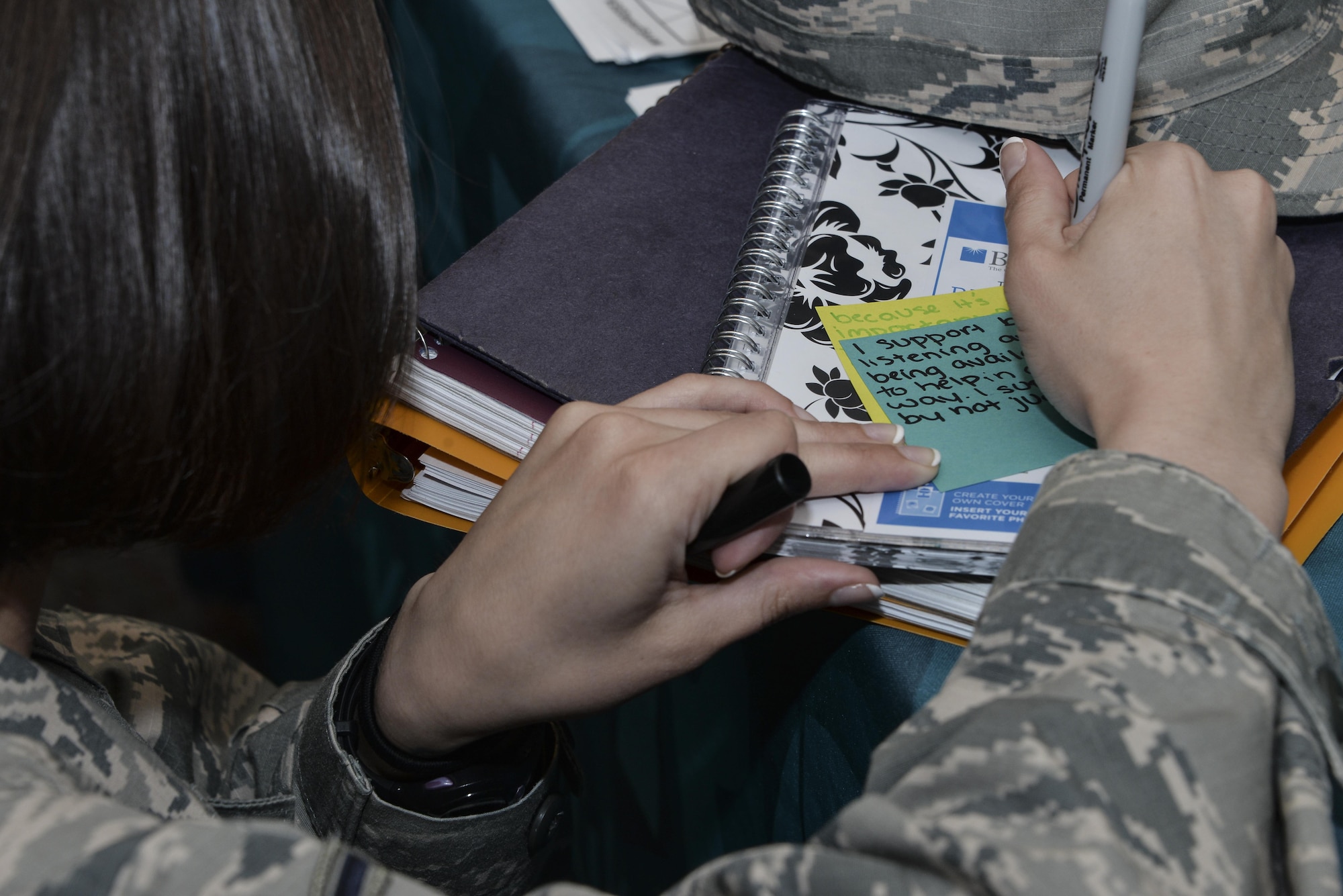 Airman Amanda, 32nd Intelligence Squadron, writes a message to sexual assault survivors on a sticky note as part the Stick with Survivors project April 13. Stick with Survivors is a project created by the 70th Intelligence, Surveillance and Reconnaissance Wing Sexual Assault and Response office that will assist military and civilian members in showing their support for sexual assault survivors. (U.S. Air Force photo by Staff Sgt. Alexandre Montes)