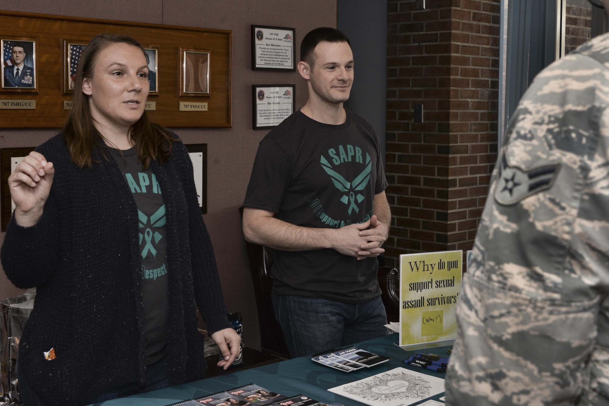 Staff Sgt. Melissa and Capt. Robert, 7th Intelligence Squadron volunteer victim advocates, talk to 70th Intelligence, Surveillance and Reconnaissance Wing Airmen about the Stick with Survivors project April 13. Stick with Survivors is a project created by the 70th ISRW Sexual Assault Prevention and Response office that will assist military and civilian members in showing their support for sexual assault survivors. (U.S. Air Force photo by Staff Sgt. Alexandre Montes)