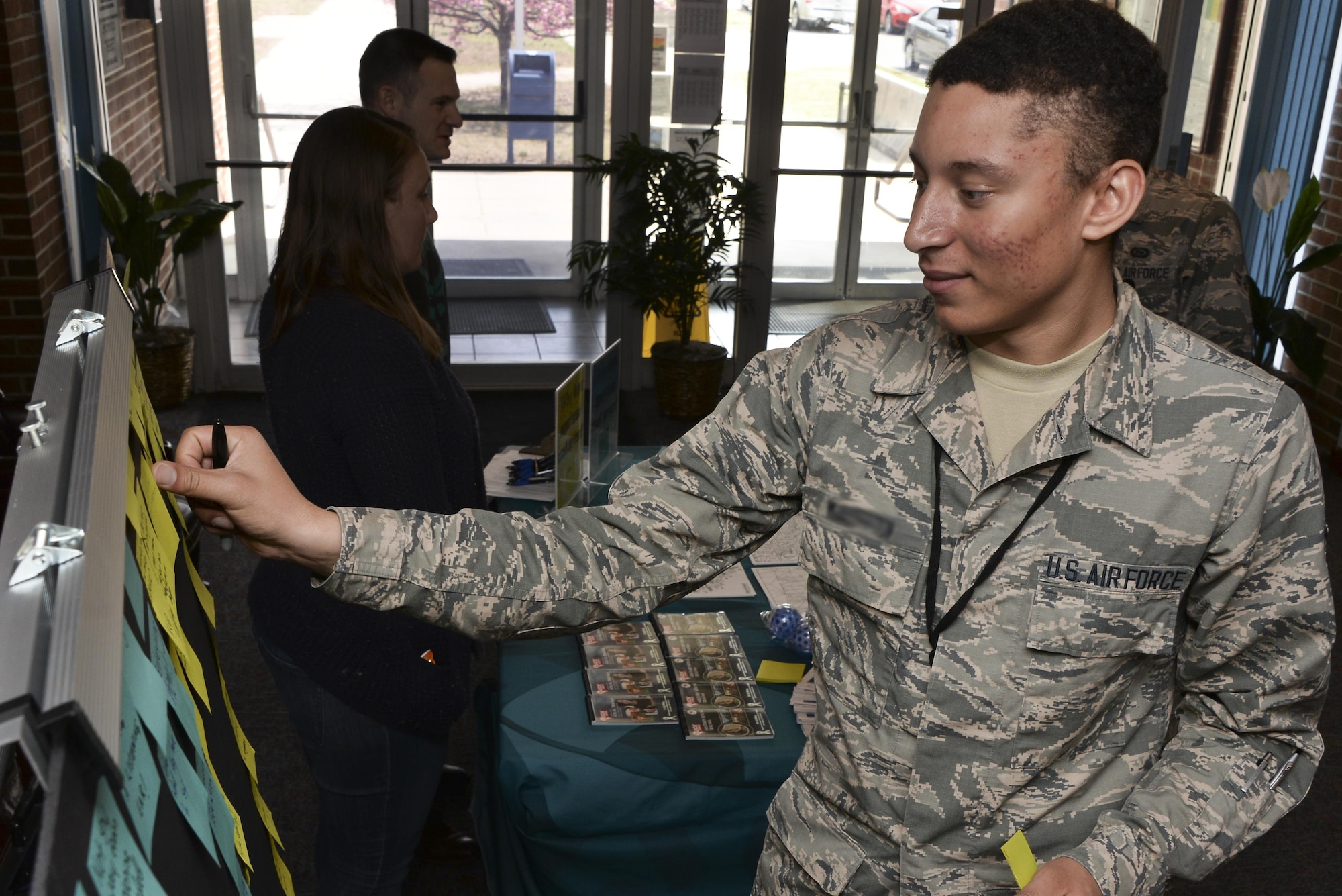 Airman 1st Class Nicholas, 22nd Intelligence Squadron, adds a sticky note with his supportive message to the Stick with Survivors board April 13. Stick with Survivors was created by the 70th Intelligence, Surveillance and Reconnaissance Wing Sexual Assault Prevention and Response office that will assist military and civilian members in showing their support for sexual assault survivors.  (U.S. Air Force photo by Staff Sgt. Alexandre Montes)