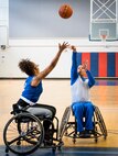 Jaquari Lopez tries to block as Israel Delgado Jr., takes his shot during the Warrior CARE wheelchair basketball session of the adaptive sports camp at Eglin Air Force Base, Fla., April 26. The base hosts the week-long Wound Warrior CARE event that helps recovering wounded, ill and injured military members through specific hand-on rehabilitative training. (U.S. Air Force photo/Samuel King Jr.)