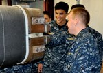 DAHLGREN, Va. (April 14, 2017) - U.S. Naval Academy Midshipmen peer down the barrel of the electromagnetic railgun prototype launcher at Naval Surface Warfare Center Dahlgren Division. Navy scientists and engineers briefed the Midshipmen on electromagnetic launchers, hypervelocity projectiles, and directed energy weapons, in addition to the command's capabilities in complex warfare systems development and integration to incorporate electric weapons technology into existing and future fighting forces and platforms.