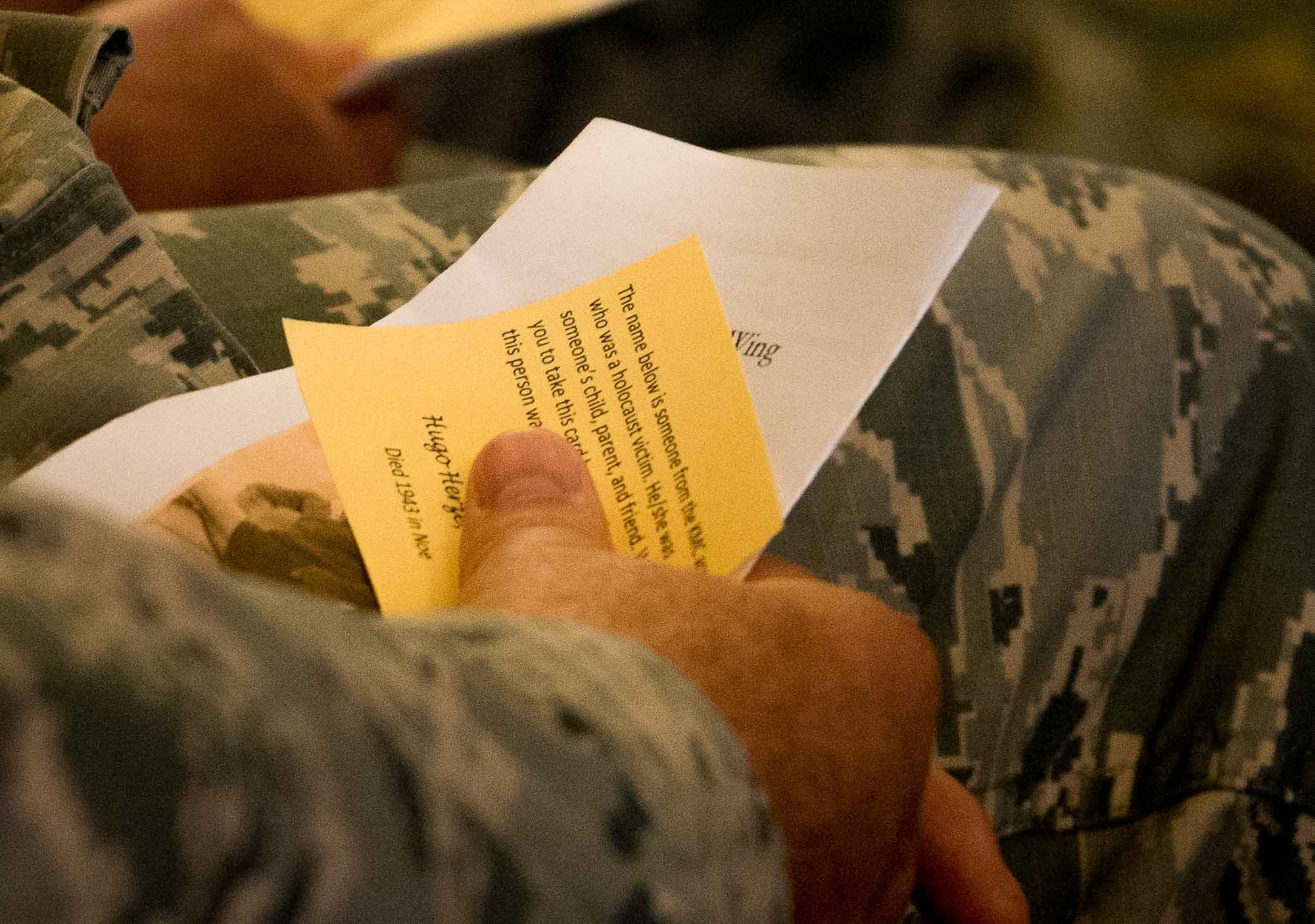 An Airmen holds a card with the name of a Holocaust victim from the Kaiserslautern Community at Ramstein Air Base, Germany, April 25, 2017. The cards were given to attendees during the 86th Airlift Wing’s Holocaust Remembrance in order to honor all who were persecuted in the Holocaust as well as anyone who has been affected by the tragedy, including rescuers and U.S. soldiers who risked their lives during the liberation. (U.S. Air Force photo by Senior Airman Elizabeth Baker)