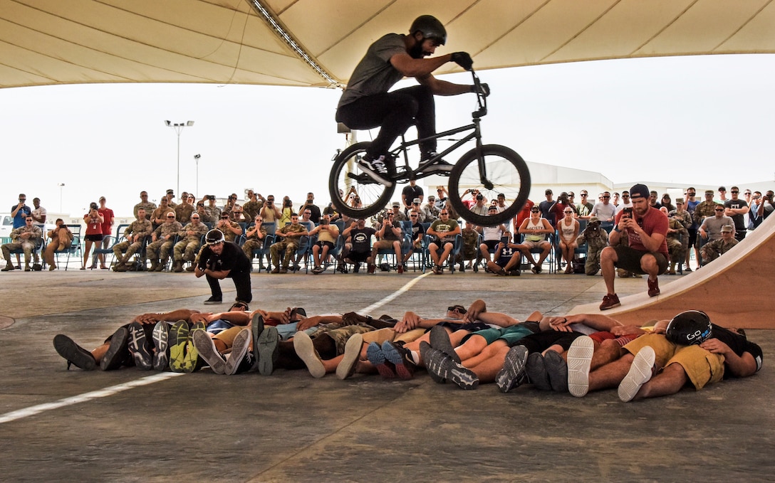 Mykel Larrin, a Bikes Over Baghdad BMX rider, jumps over service members at Al Udeid Air Base, Qatar, April 20, 2017. Bikes Over Baghdad is a professional team of BMX Riders who travel throughout the U.S. Central Command area of responsibility putting on shows for service members. (U.S. Air Force photo by Senior Airman Cynthia A Innocenti)