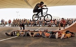 Mykel Larrin, a Bikes Over Baghdad BMX rider, jumps over service members at Al Udeid Air Base, Qatar, April 20, 2017. Bikes Over Baghdad is a professional team of BMX Riders who travel throughout the U.S. Central Command area of responsibility putting on shows for service members. (U.S. Air Force photo by Senior Airman Cynthia A Innocenti)