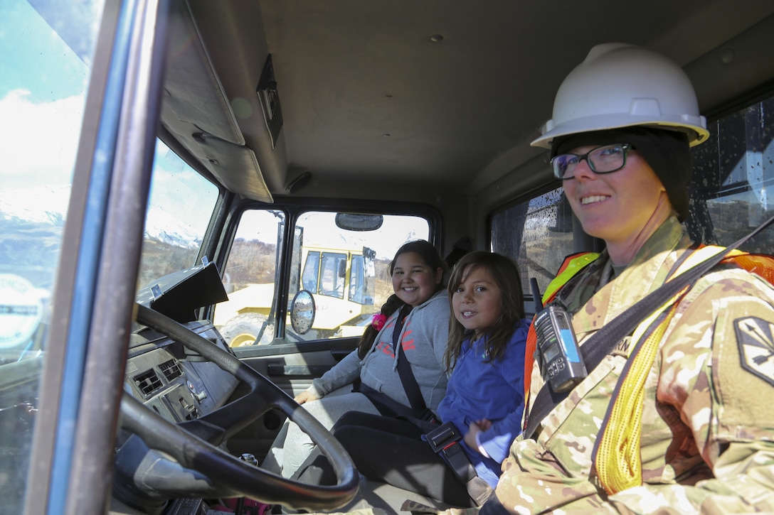 Army Pfc. Amanda Schmidling, a horizontal construction engineer with the Arizona National Guard’s 259th Engineer Platoon, drives local students around during their visit to an Innovative Readiness Training runway extension project at Old Harbor, Alaska, April 20, 2017. Army photo by Staff Sgt. Balinda O’Neal Dresel