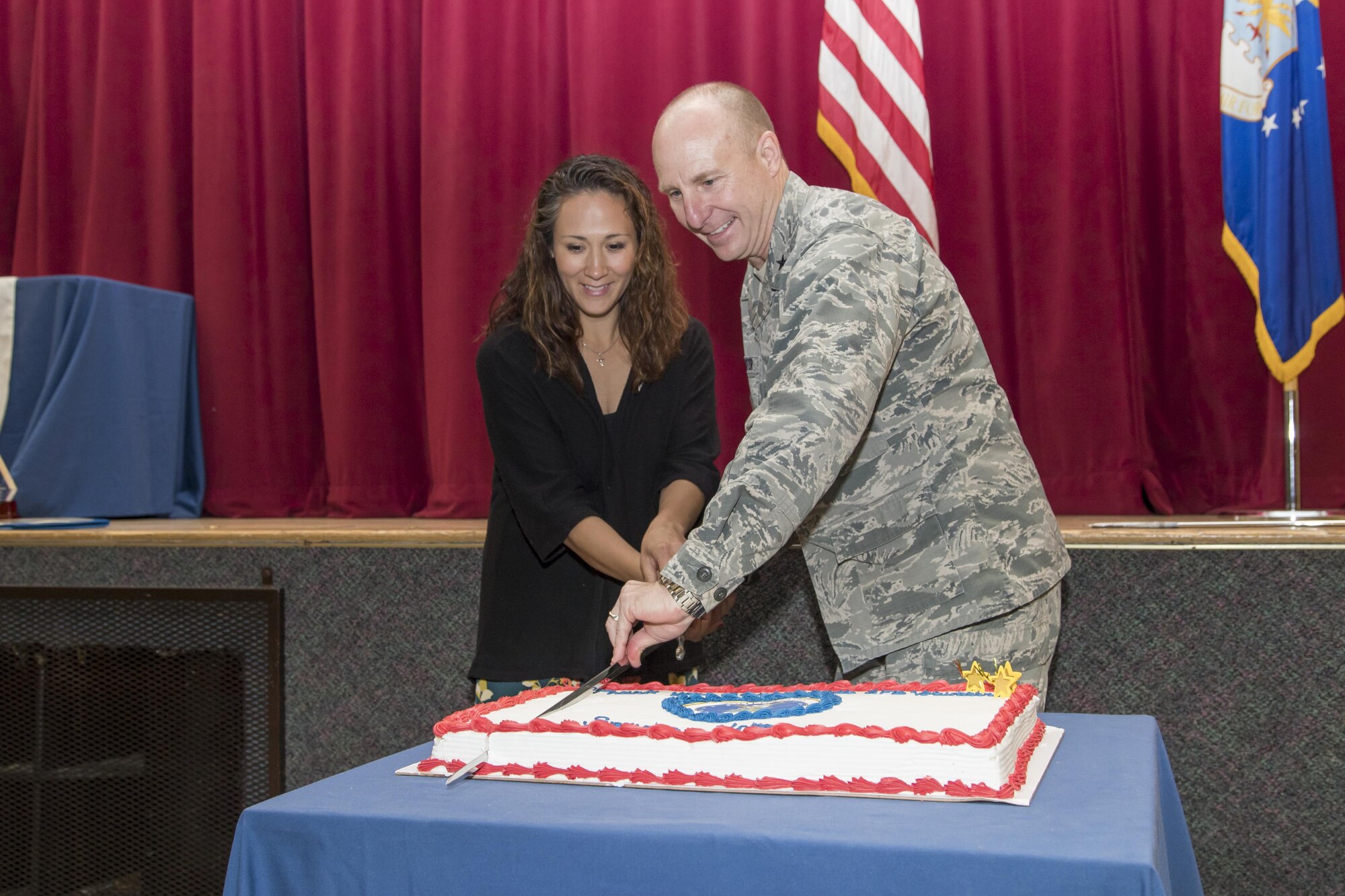Brig. Gen. Carl Schaefer, 412th Test Wing commander, and Megan Rosario cut the ceremonial cake with a sabre during Edwards AFB’s annual Volunteer Appreciation Ceremony held at the Oasis Community Center April 19. Rosario is this year’s Air Force Volunteer Excellence Award recipient for the base. (U.S. Air Force photo by Christopher Higgins)