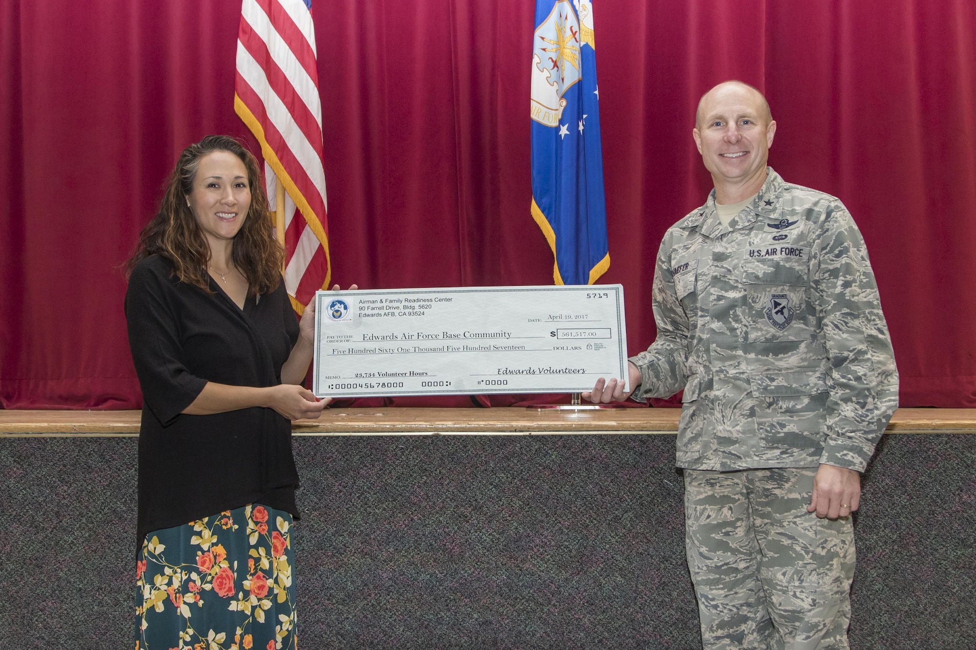 Brig. Gen. Carl Schaefer, 412th Test Wing commander, and Megan Rosario cut the ceremonial cake with a sabre during Edwards AFB’s annual Volunteer Appreciation Ceremony held at the Oasis Community Center April 19. Rosario is this year’s Air Force Volunteer Excellence Award recipient for the base. (U.S. Air Force photo by Christopher Higgins)