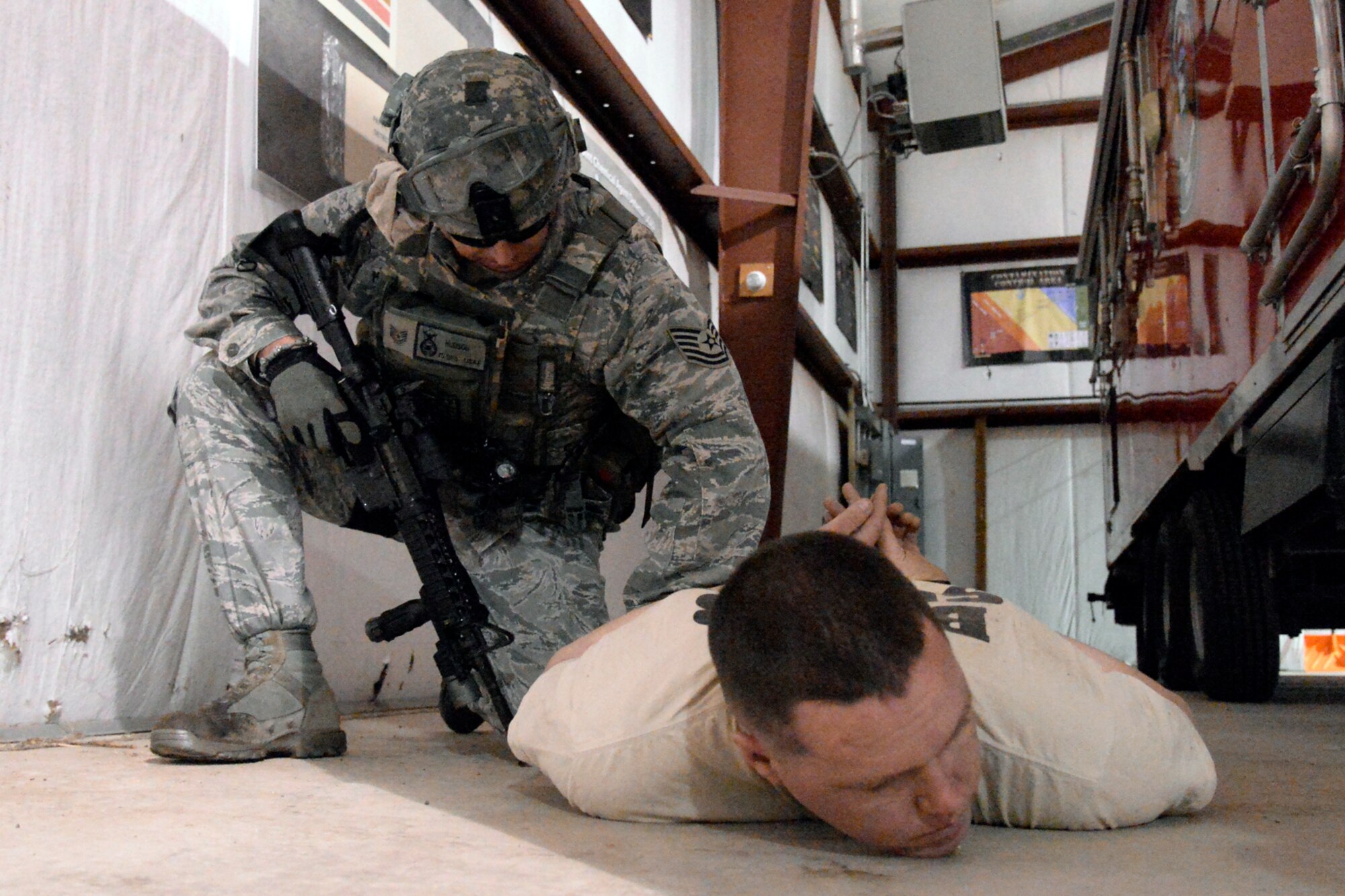 Tech. Sgt. Mark Hudson, 75th Security Forces Squadron, detains an Airman playing the role of an active shooter, Senior Airman David Andrews, 775th Civil Engineer Squadron, during a response exercise at Hill Air Force Base, April 24. (U.S. Air Force/Todd Cromar)
