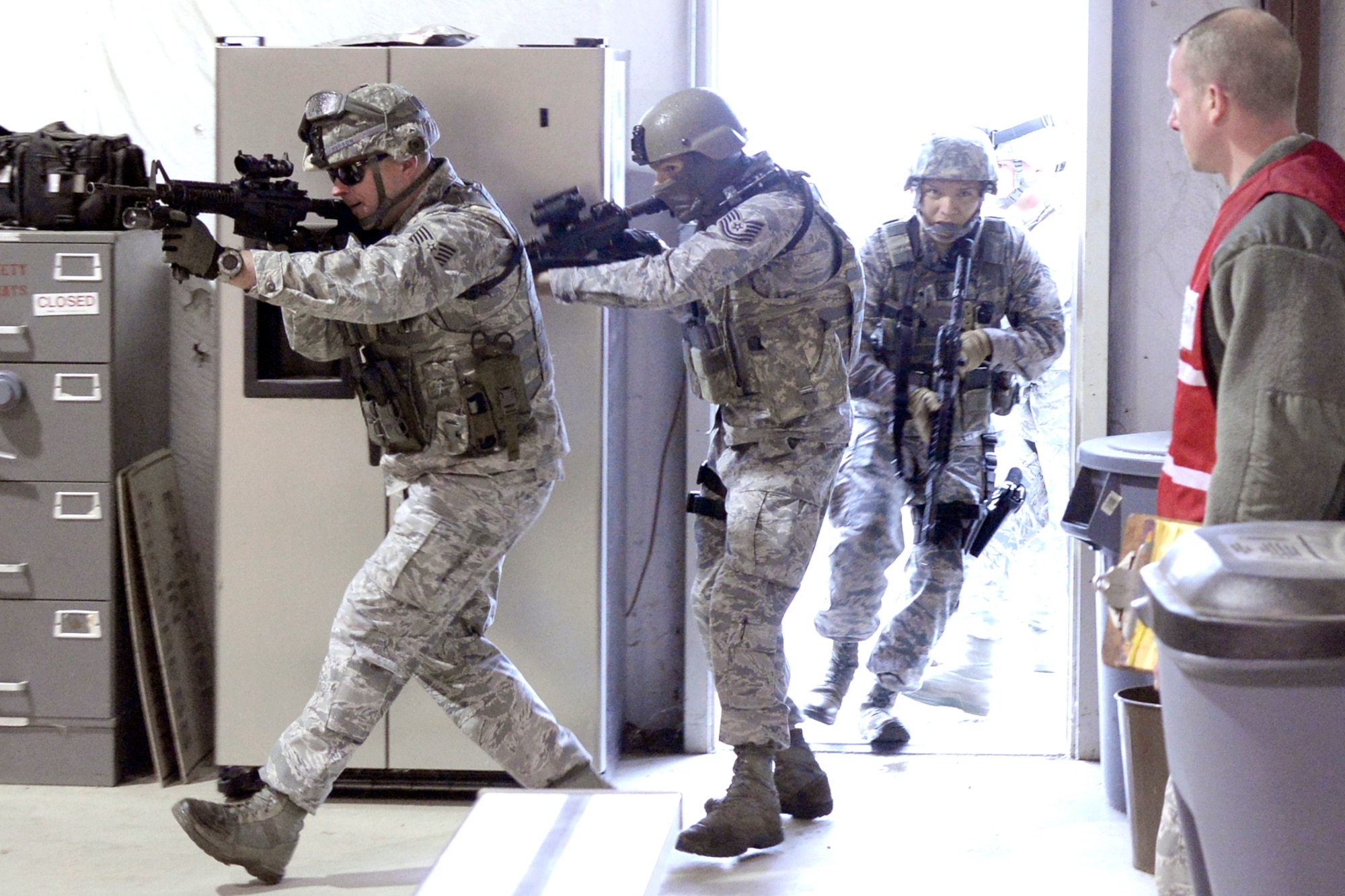 From the left, Tech. Sgt. Mark Hudson, Tech. Sgt. Kenneth Willingham and Senior Airman Jesus Reuda, all 75th Security Forces Squadron, burst into building 732 at Hill Air Force Base, April 24. The Airmen were participating in an active shooter response exercise. (U.S. Air Force/Todd Cromar)