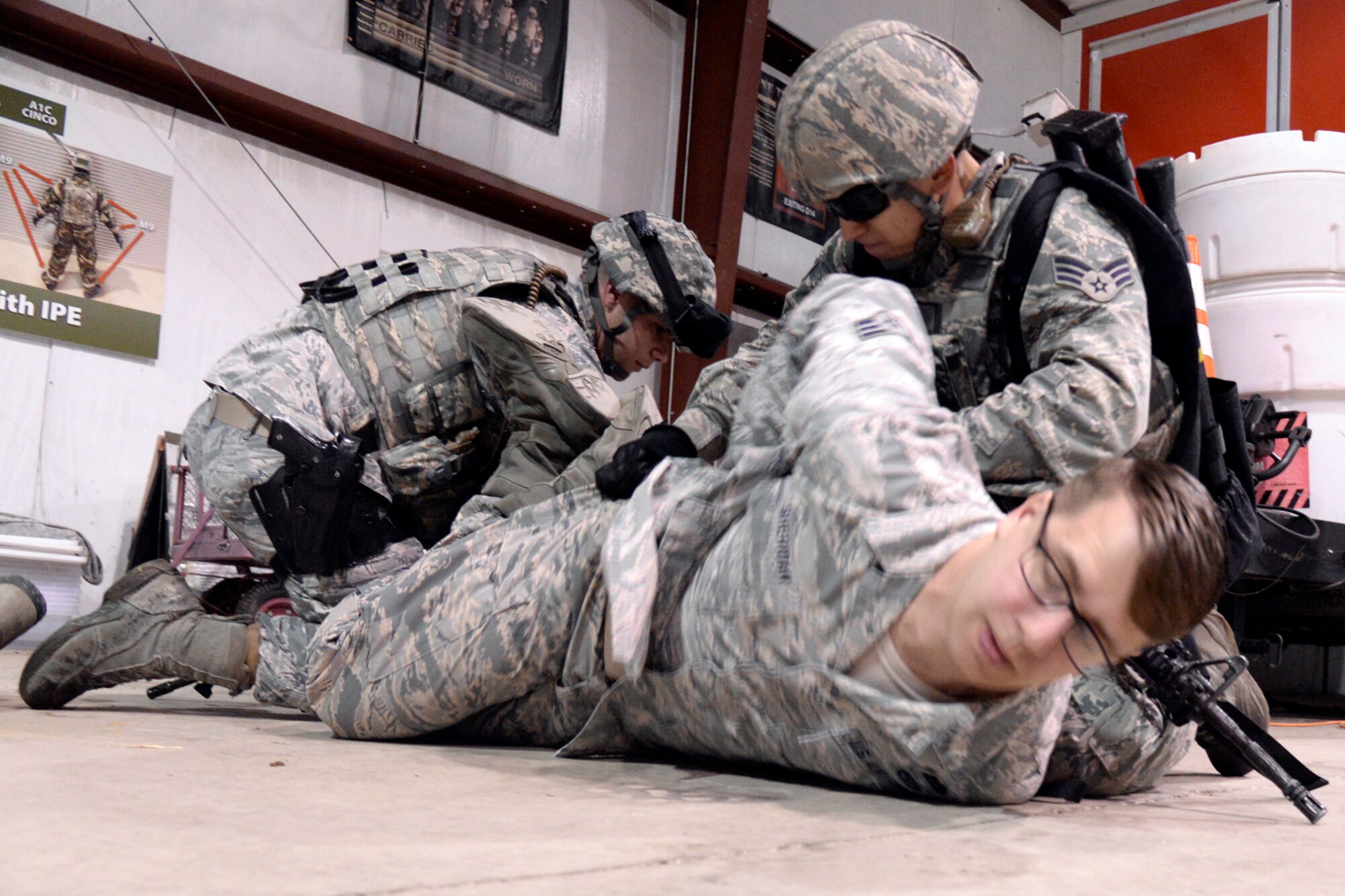 From the left, Airman 1st Class Glenn Jones and Staff Sgt. Deandre Brown, both 75th Security Forces Squadron, detain a role player, Senior Airman Alexander Sheridan, 775th Civil Engineer Squadron, during an active shooter response exercise April 24 at Hill Air Force Base. (U.S. Air Force/Todd Cromar)