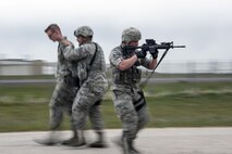 Staff Sgt. Jacob Sime, 75th Security Forces Squadron, provides cover while Staff Sgt. Jason Lyons, 75th SFS, removes Airman 1st Class Luke Litwaitis, 775th Civil Engineer Squadron, from the immediate vicinity of an active shooter during a response exercise at building 732, Hill Air Force Base, April 24. Liwaitis, who earlier ‘escaped’ and called police about an active shooter and explosives, was detained for questioning. (U.S. Air Force/Paul Holcomb)