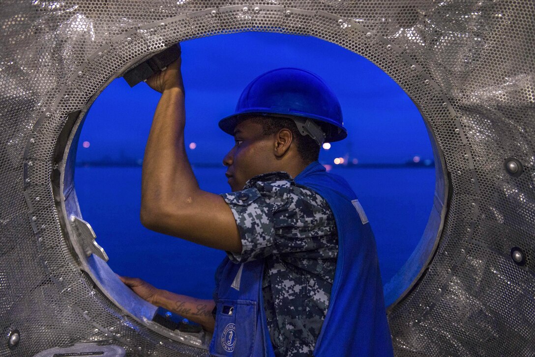 Navy Petty Officer 2nd Class Gemell Joyner watches as crews lower a rigid-hull inflatable boat into the water from the USS Coronado off Changi, Singapore, April 24, 2017. The ship is in the U.S. 7th Fleet area of responsibility, patrolling the region's littorals and working with partner navies to enhance the flexible capabilities the fleet needs now and in the future. Joyner is a logistics specialist. Navy photo by Petty Officer 3rd Class Deven Leigh Ellis
