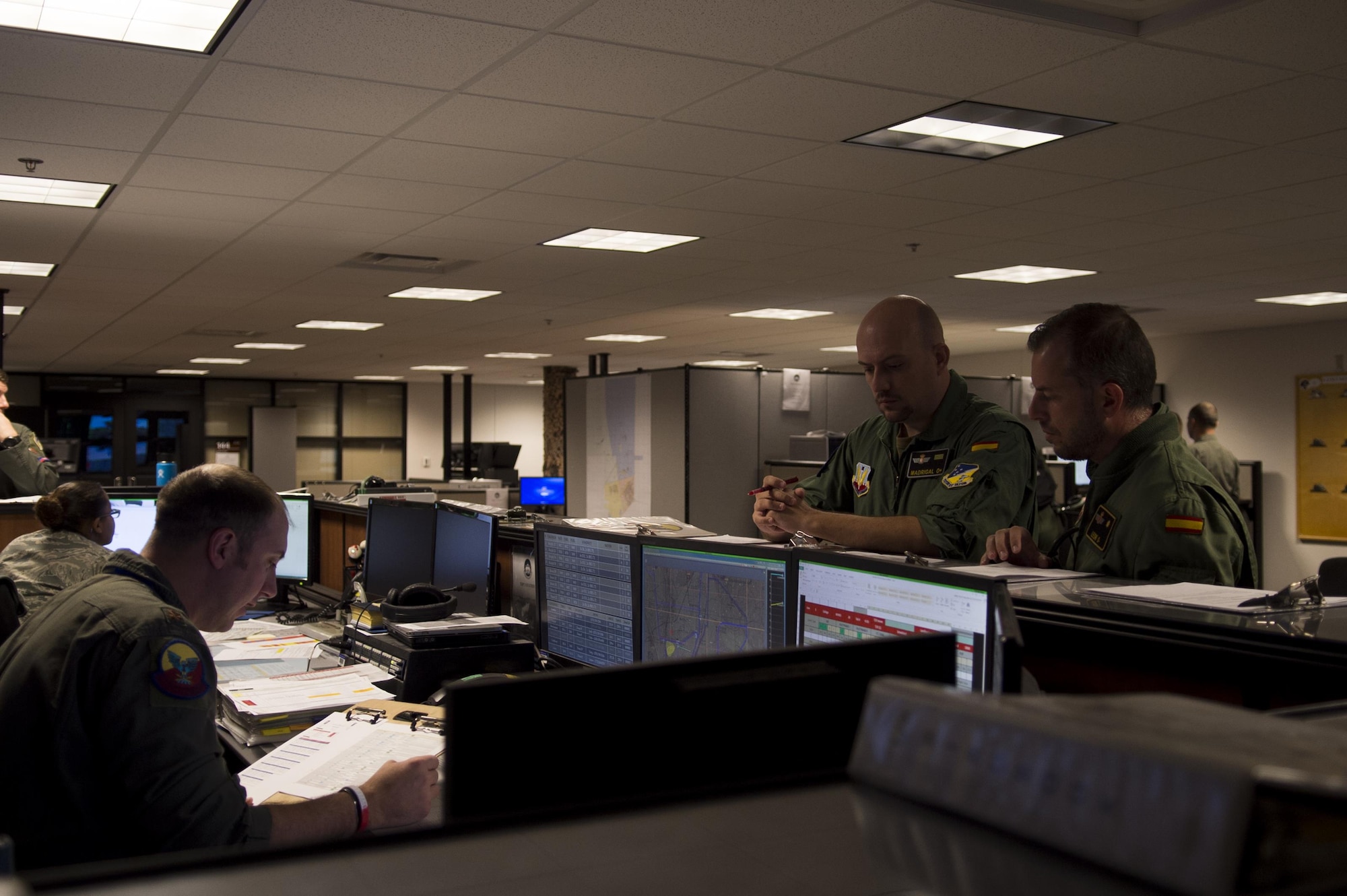 Maj. Jaime, a Spanish air force student pilot, right, and Staff Sgt. Francisco, a Spanish air force student sensor operator, middle, listen to a briefing given by a 29th Attack Squadron MQ-9 Reaper instructor pilot at Holloman Air Force Base, N.M. on April 5, 2017. Spain is currently participating in essential training here at the MQ-9 formal training unit. (U.S. Air Force photo by Tech. Sgt. Amanda Junk)