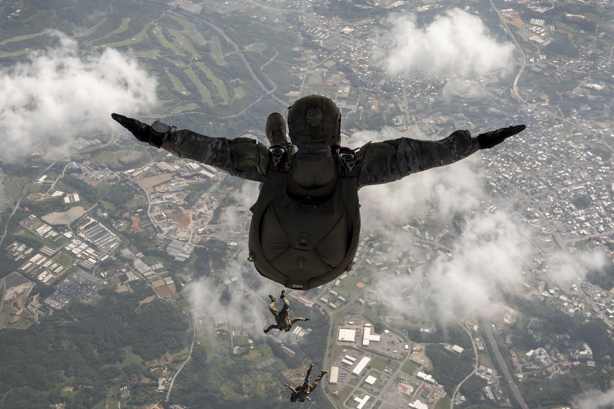 An airman spreads his arms as he jumps from an aircraft.