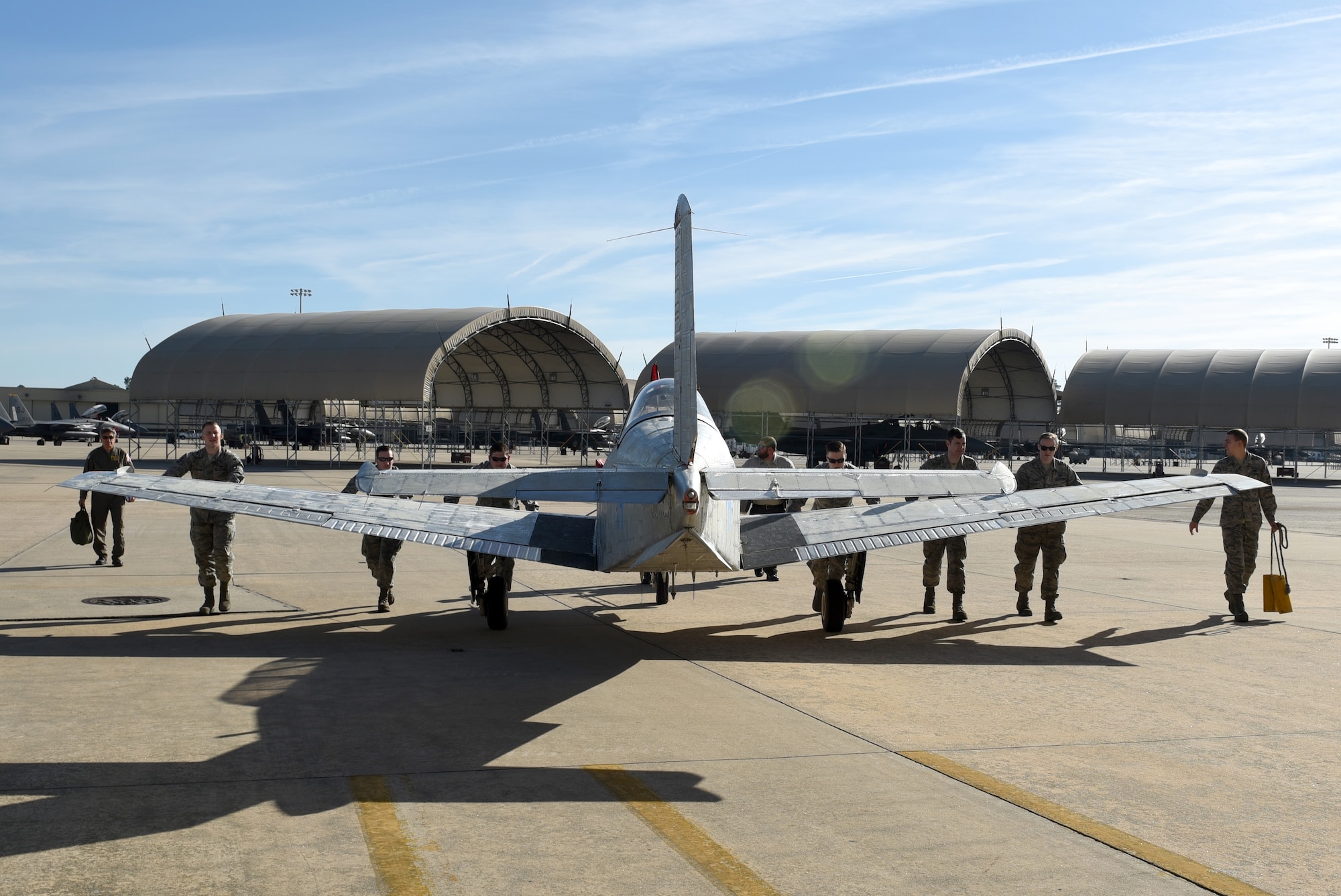 Members from the 4th Equipment Maintenance Squadron corrosion control shop guide an unpainted T-34C Turbo Mentor aircraft into a hangar, April 10, 2017, at Seymour Johnson Air Force Base, North Carolina. Members of the 4 EMS painted two T-34C Turbo Mentor planes for the North Carolina Forest Service aviation division. (U.S. Air Force photo by Airman 1st Class Victoria Boyton)