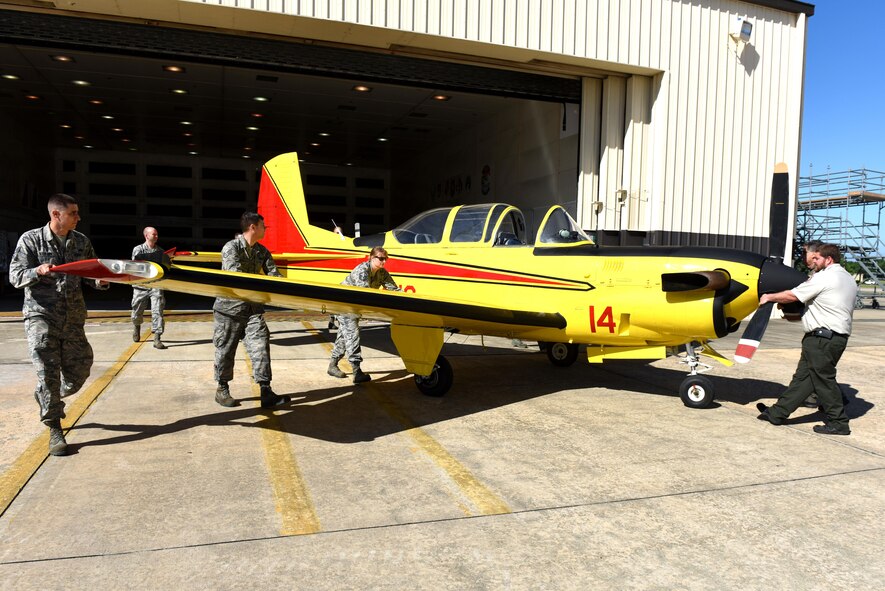 Members from the 4th Equipment Maintenance Squadron corrosion control shop guide a freshly painted North Carolina Forest Service T-34C Turbo Mentor aircraft out of the 4th Equipment Maintenance Squadron corrosion control shop, April 26, 2017, at Seymour Johnson Air Force Base, North Carolina. The aircraft is used as the lead plane to guide tankers over fires so the tankers can drop suppressant on the fire.  (U.S. Air Force photo by Airman 1st Class Ashley Williamson)